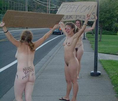 pretty nude protester girls with signs at the roadside