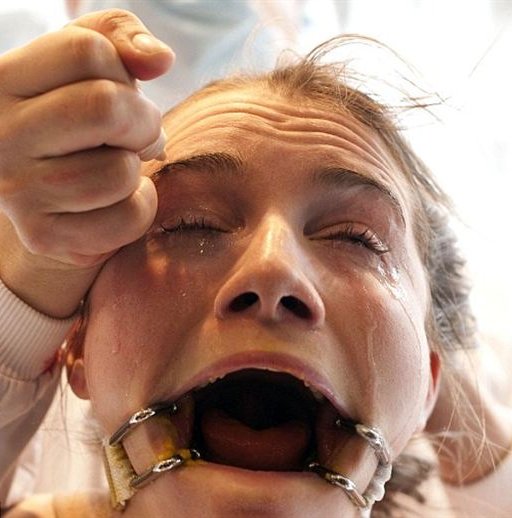 gagged woman crying as painful liquid is squirted into her eyes