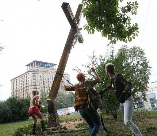 cutting down a cross with a chainsaw for Pussy Riot