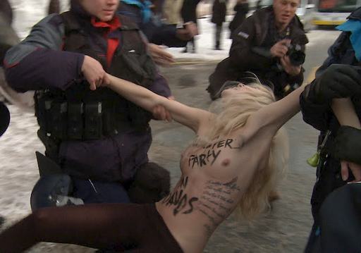 nude protester being hauled off by swiss cops