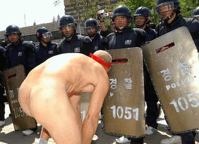 older man gets naked in front of line of riot police