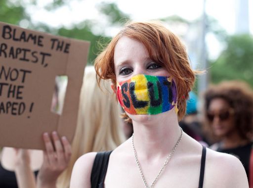 slutwalk protester wears rainbow tape gag labeled slut